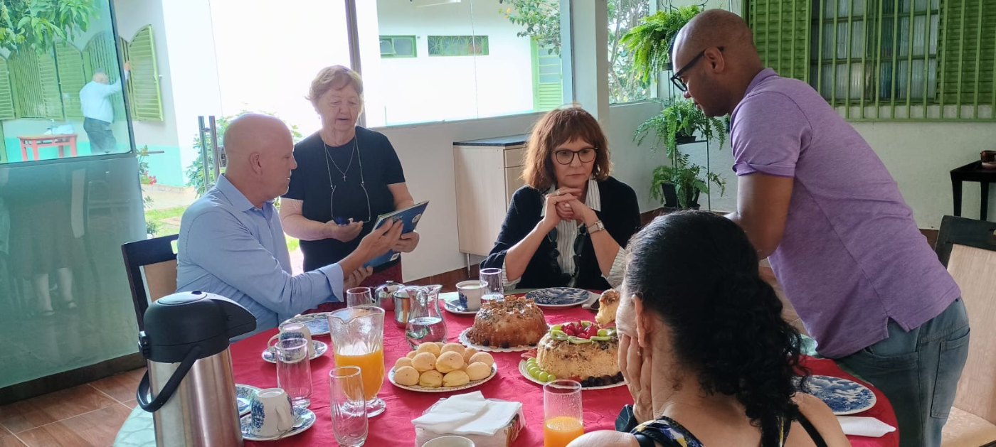 Visitantes da Alemanha reunidos à mesa com a equipe da Casa da Esperança